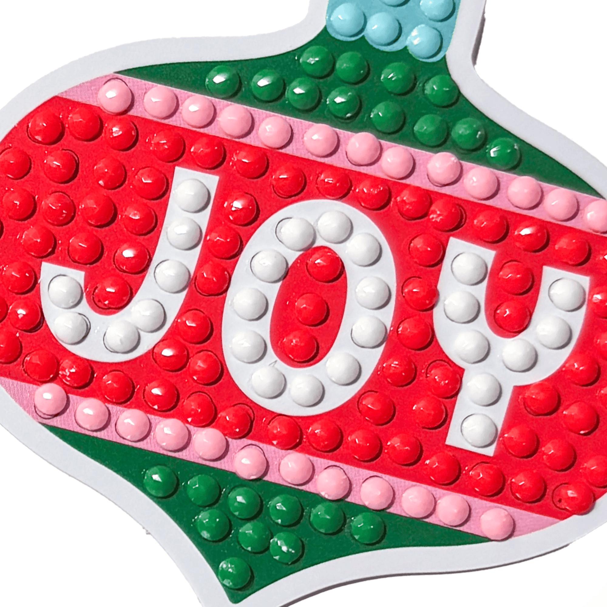 Colorful 'JOY' sign made of interlocking bricks on a white background