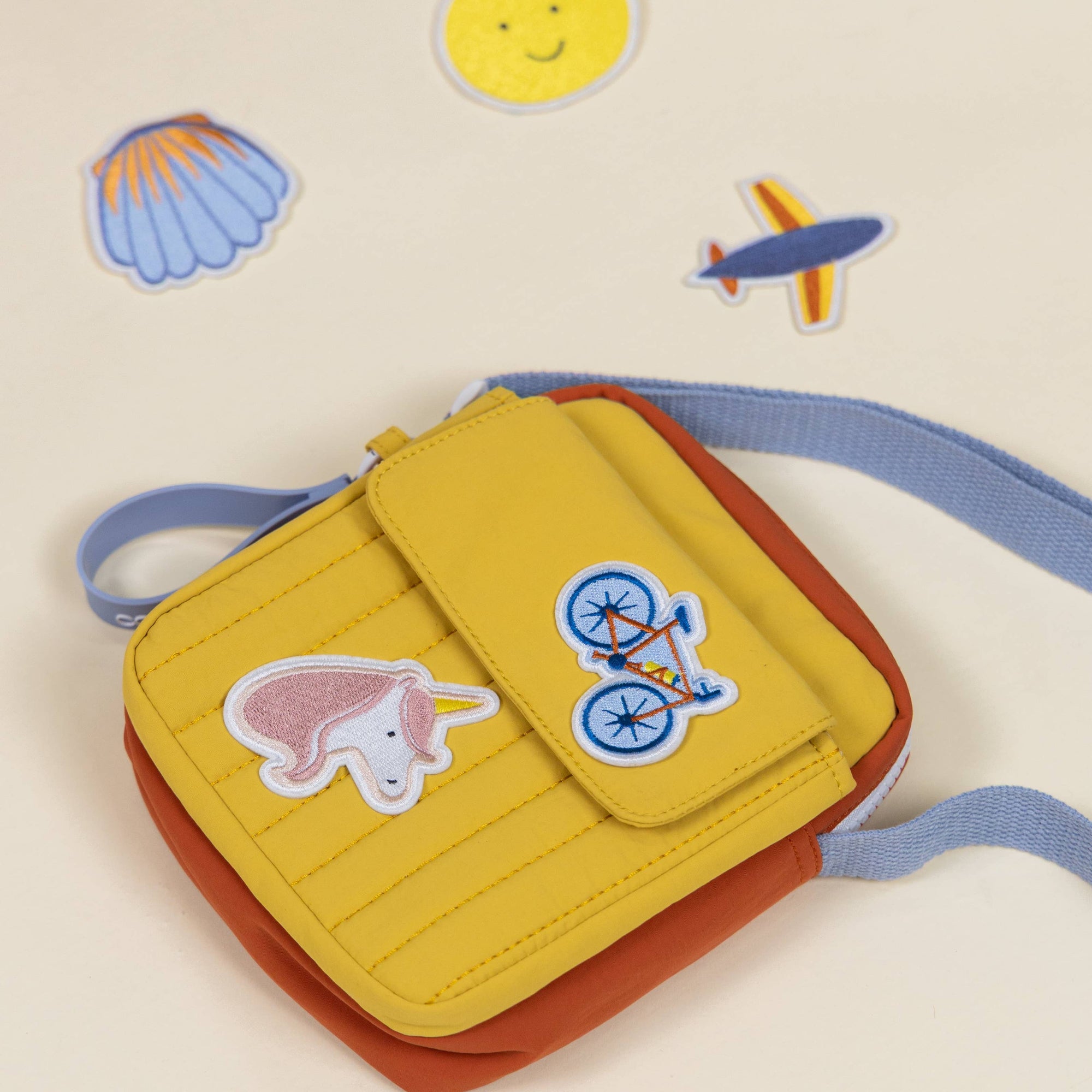 Yellow and orange pouch with cartoon designs on a light beige background