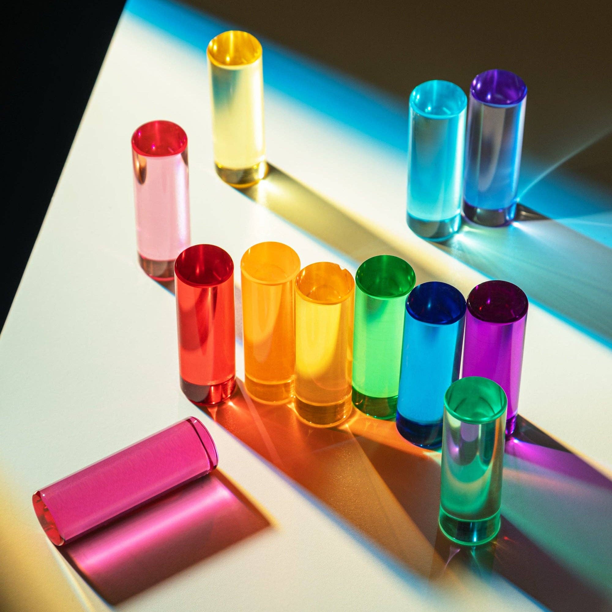 Set of colorful pieces on a reflective surface with a bright light background.