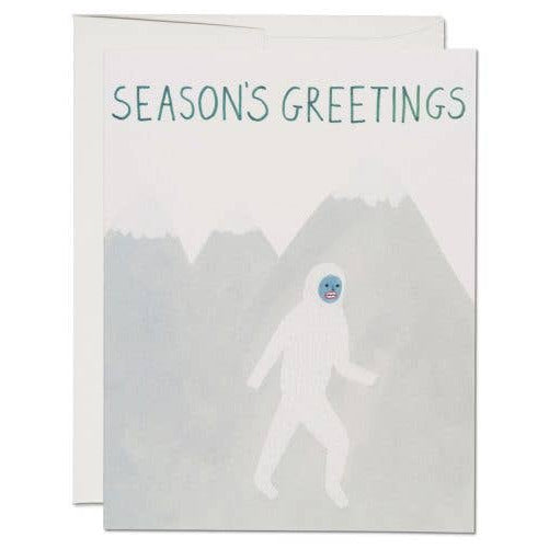 Greeting card with 'Season's Greetings' text and a silhouette of a person in a snowsuit against a mountain background.