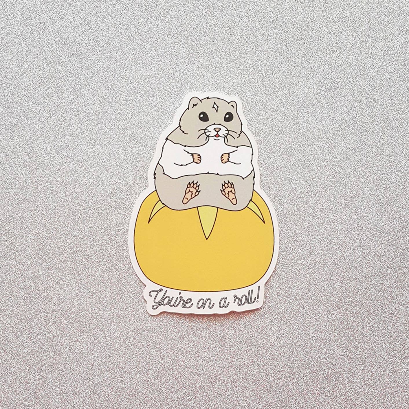 Sticker of a beaver in a diaper with text 'You're on a roll!' on a gray background