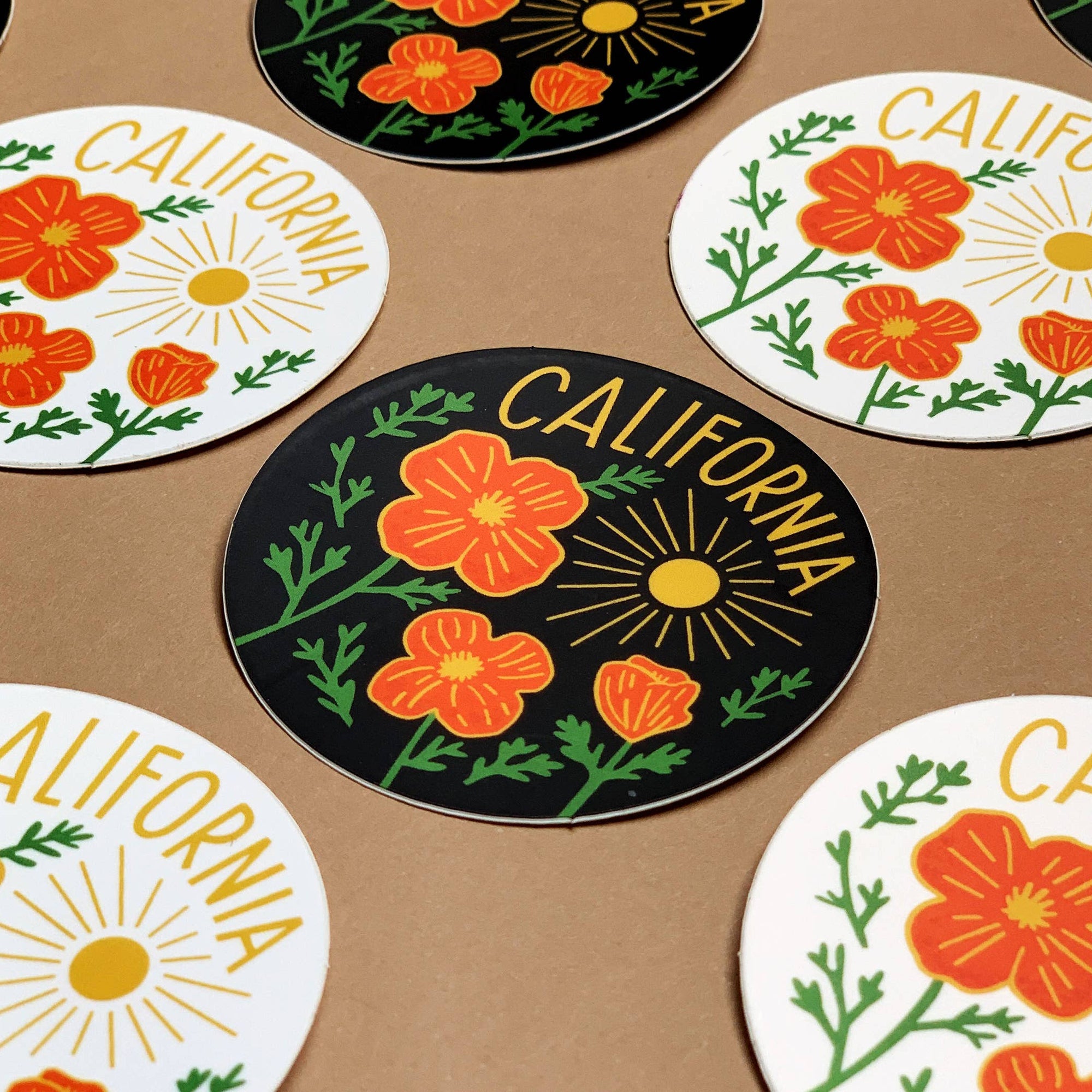 Set of coasters with California-themed designs on a brown surface