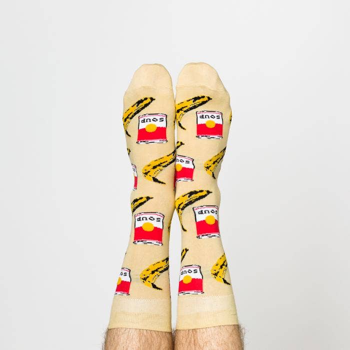 Beige socks with soup can and banana pattern on a white background