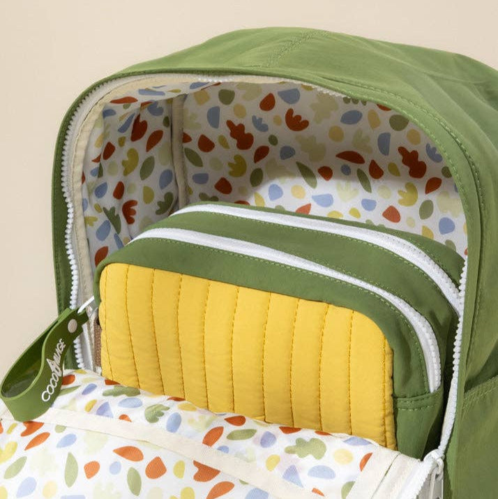 Green baby bag with colorful interior lining and yellow cushion
