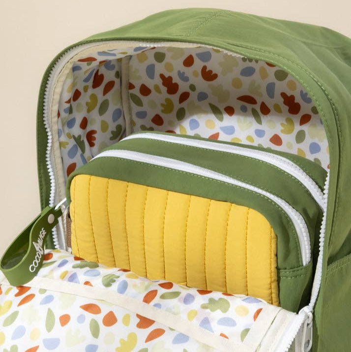 Green baby bag with colorful interior lining and yellow cushion
