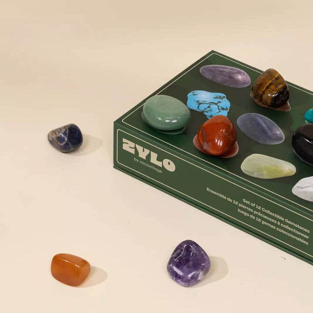 Set of colorful stones in front of a ZYLO branded box on a beige background
