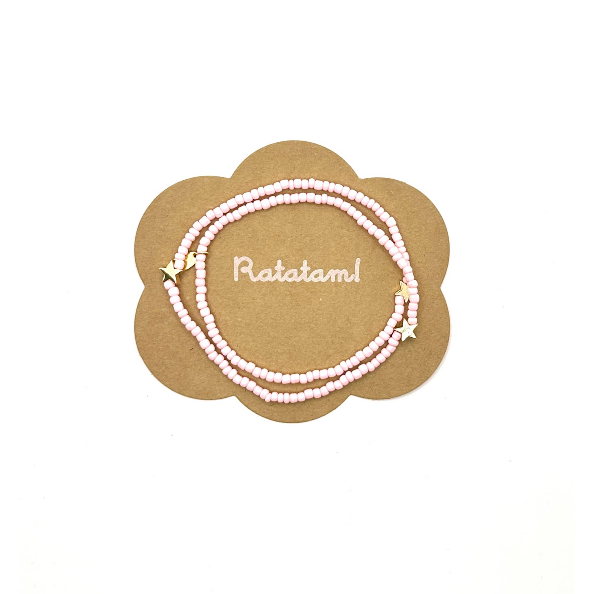 Set of pink beaded necklace with gold accents on a decorative card 