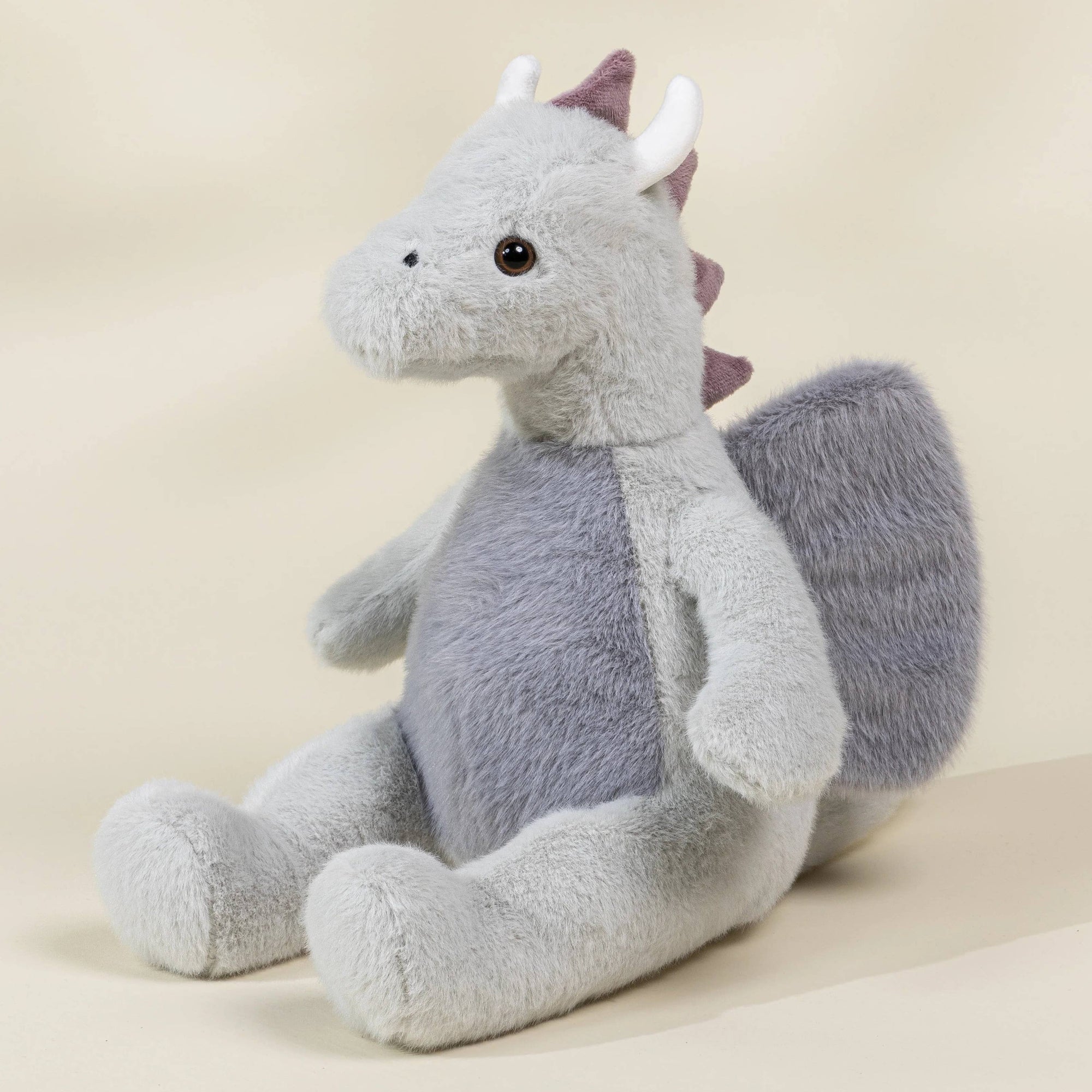 Plush dragon toy on a beige background