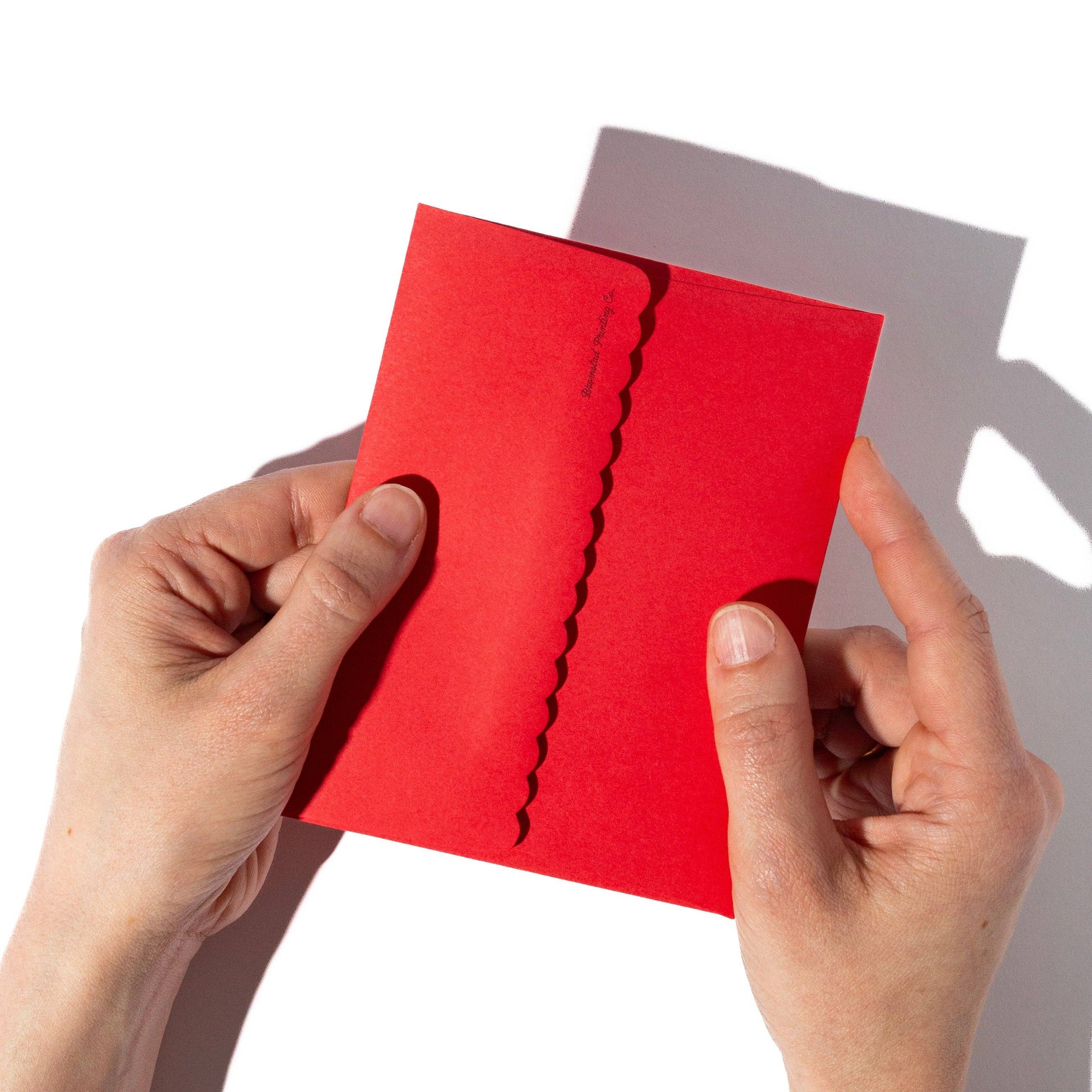 Red envelope with a crack held by hands against a white background