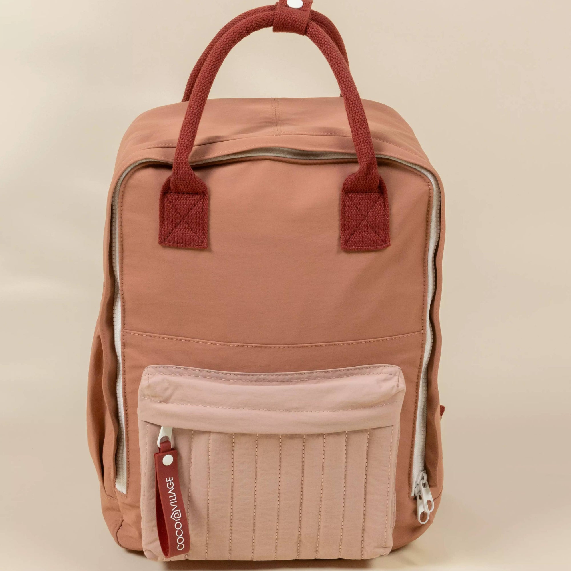 Pink backpack with a visible brand logo on a beige background
