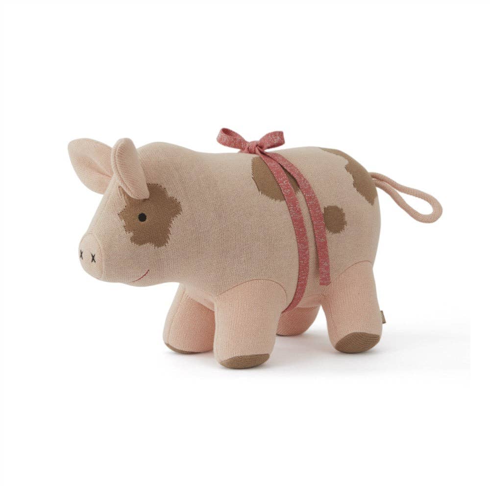 Stuffed animal cow with a pink ribbon on a white background