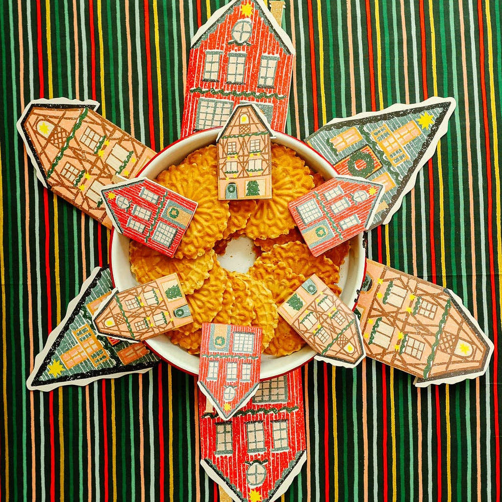 Decorative arrangement of small houses around a bowl of cereal on a striped background