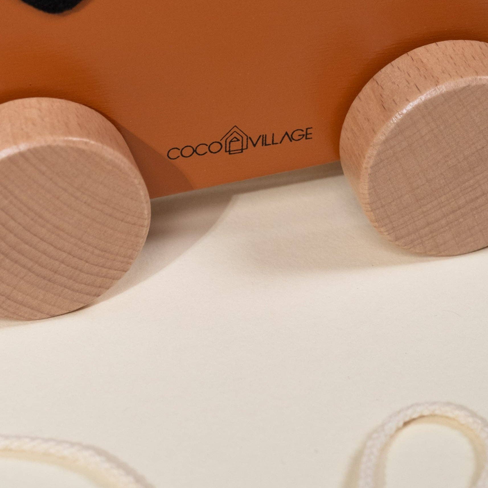 Wooden toy car with 'Coco Village' branding on a white background