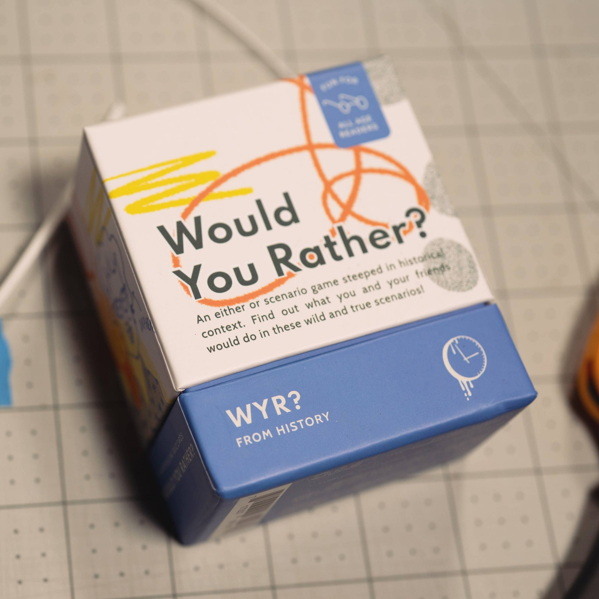 Box of 'Would You Rather?' game on a grid background