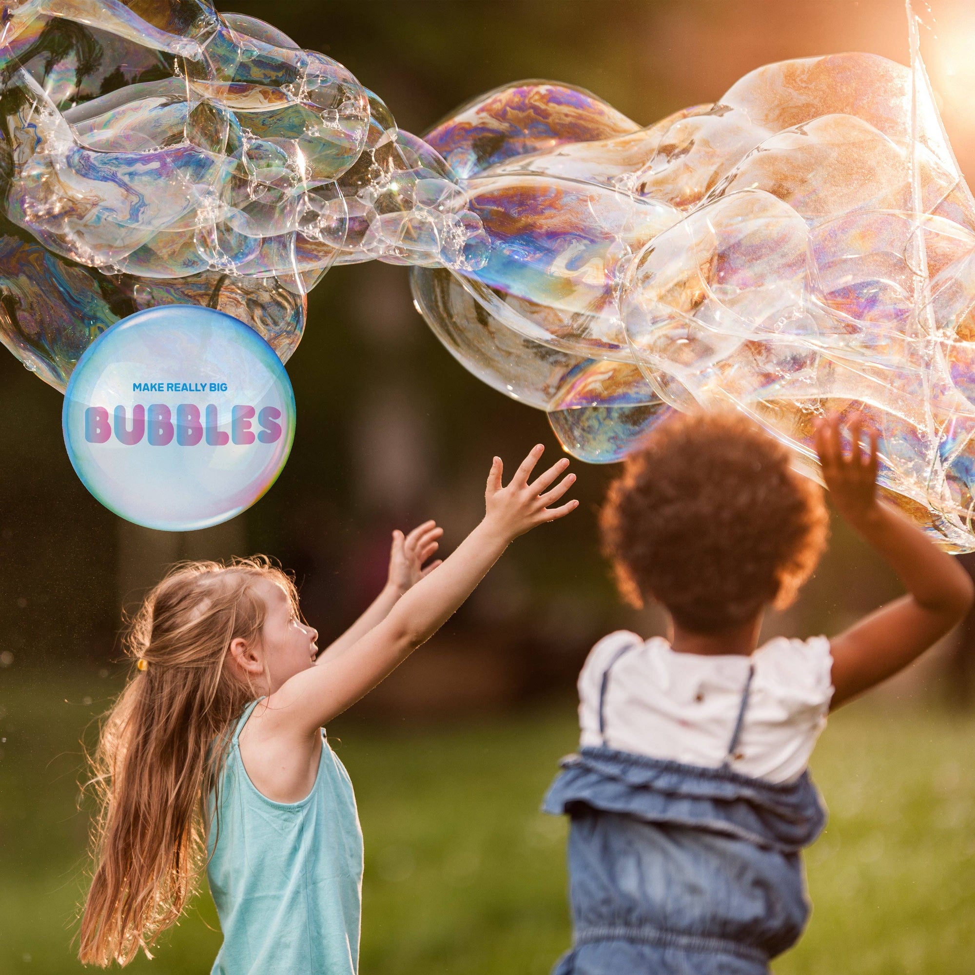 Two children playing with large bubbles in a park setting.