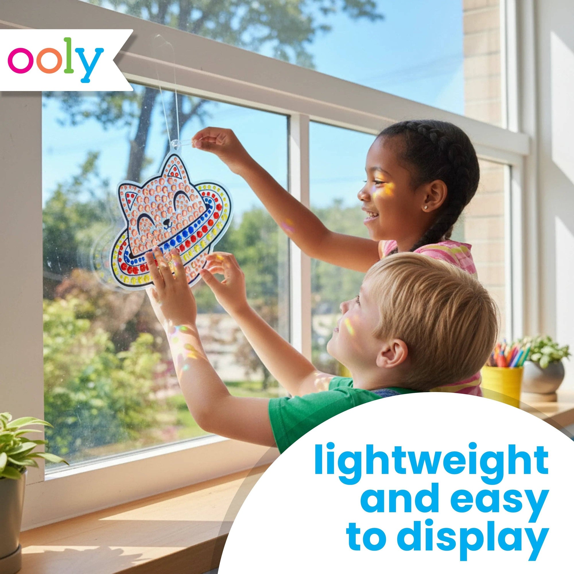 Two children decorating a window with colorful stickers, featuring the brand 'ooly'.