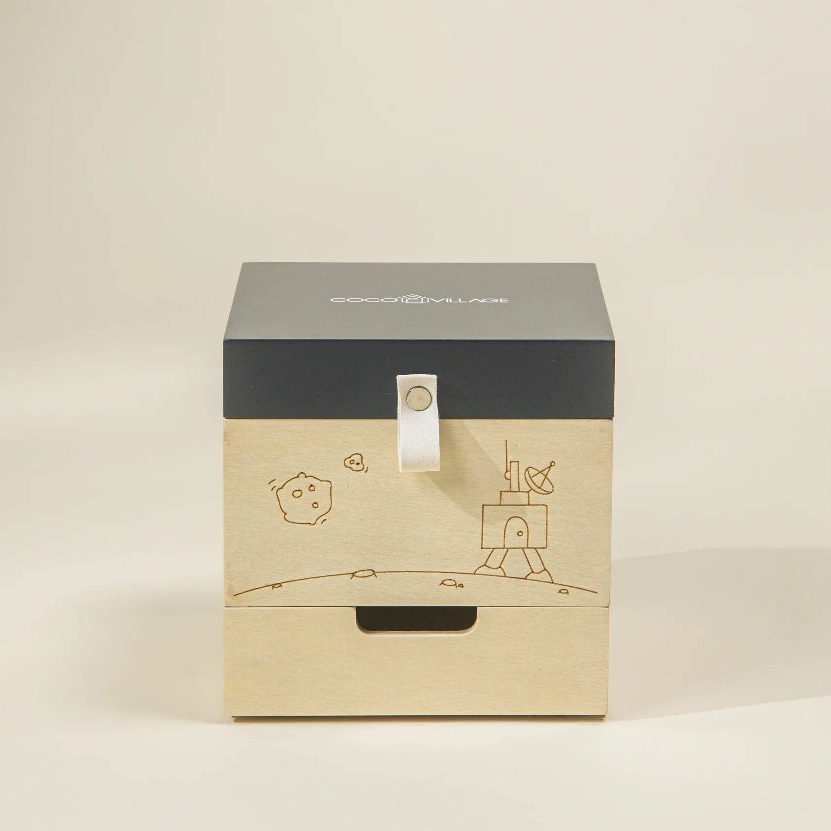 Wooden box with black lid featuring illustrations on a beige background