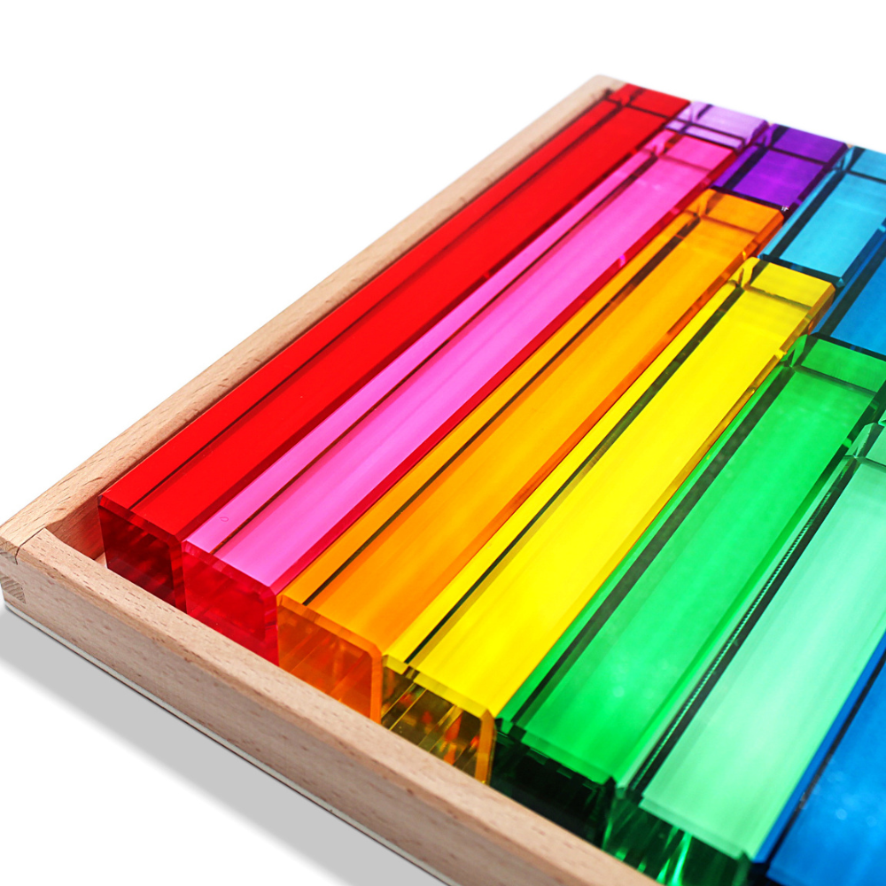 Colorful transparent blocks in a wooden box on a white background