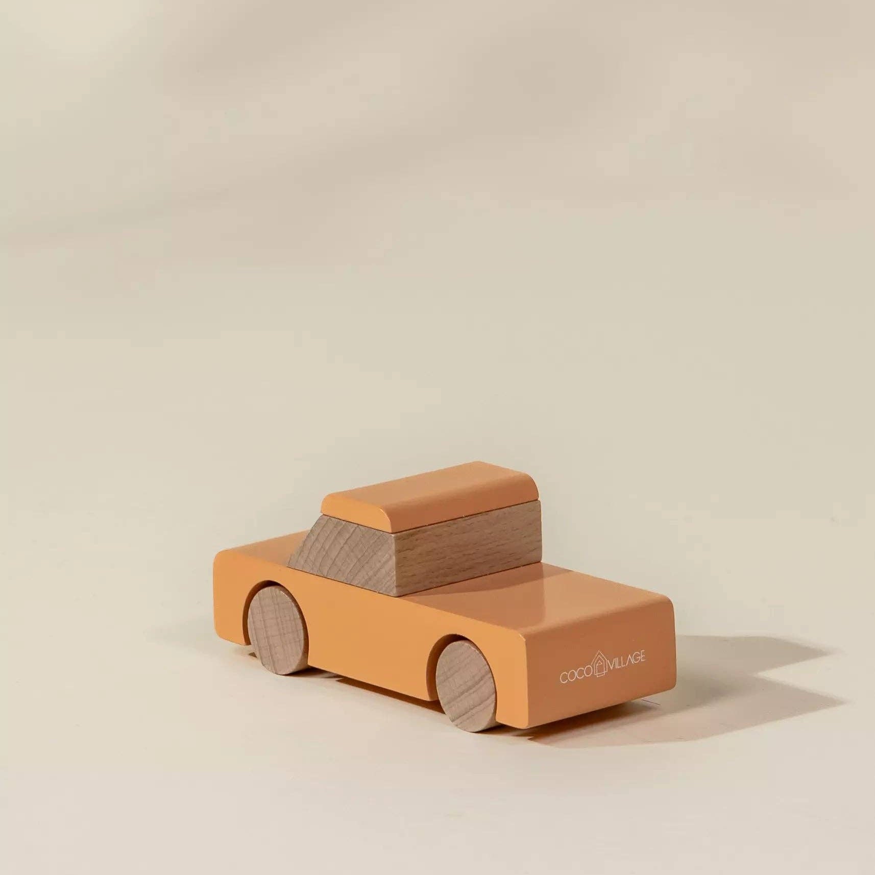 Wooden toy car on a beige background