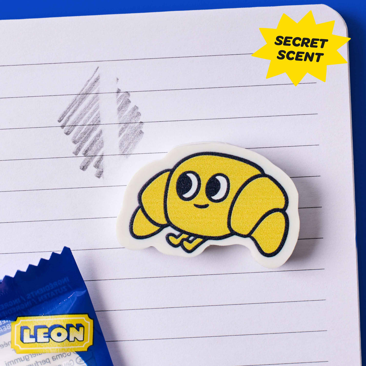 Yellow cartoon character eraser on lined paper with 'Secret Scent' label and Leon branding.