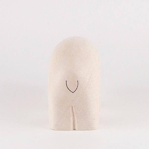 Beige pillow with a black smiley face design on a white background