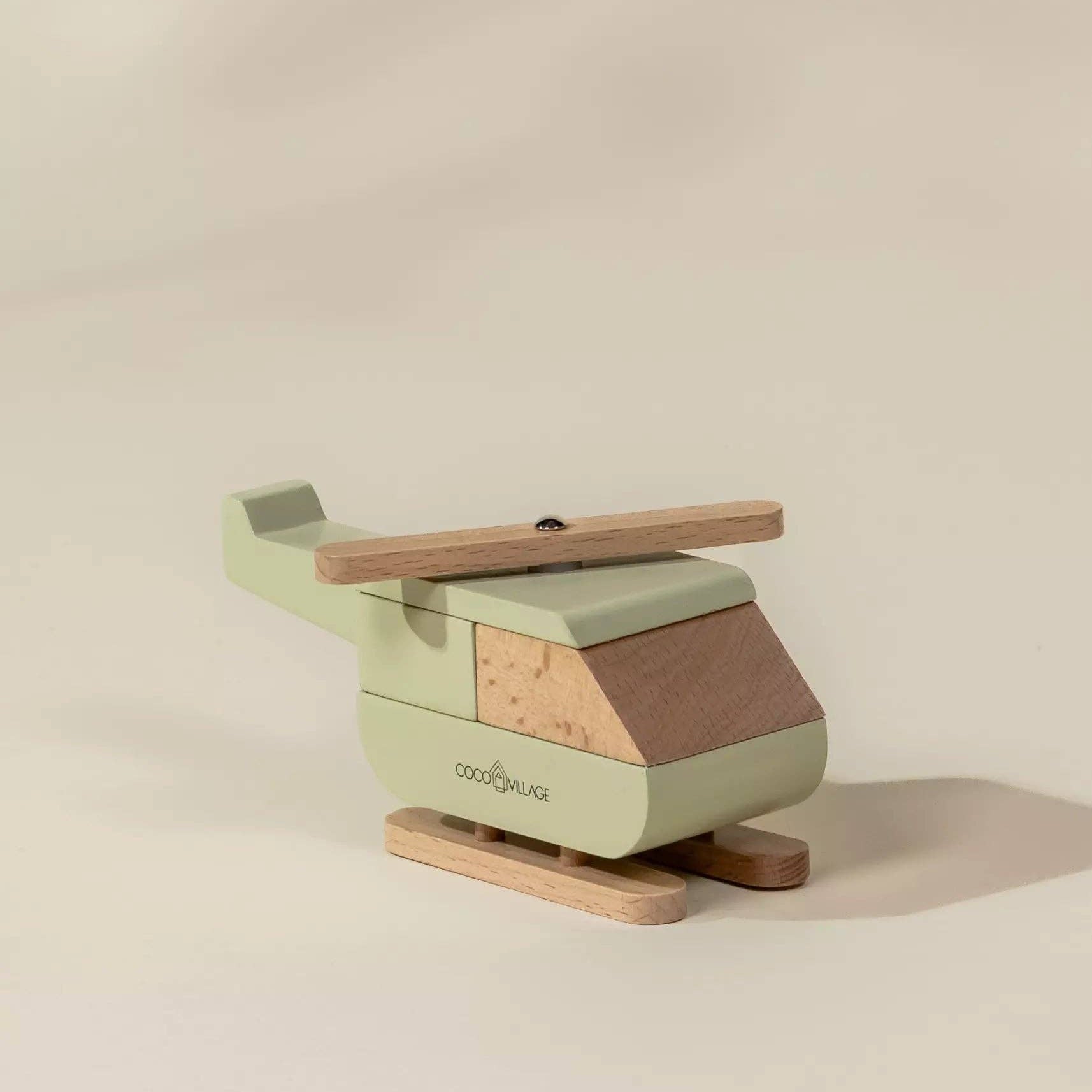 Green and brown wooden toy helicopter on a beige background
