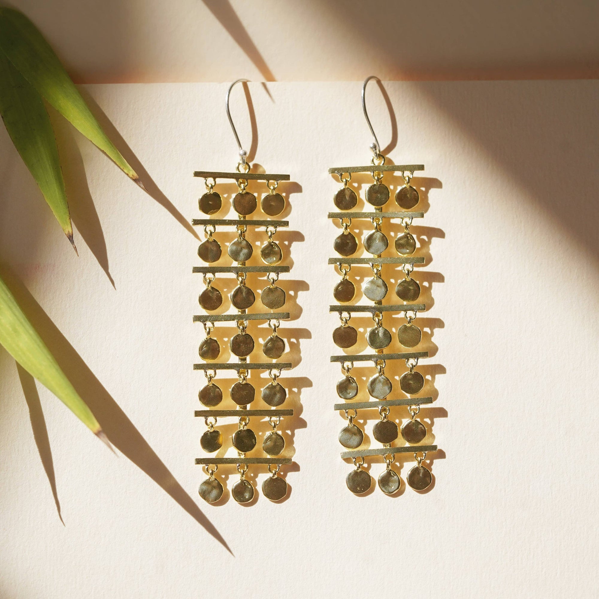 Gold and silver dangling earrings on a light background