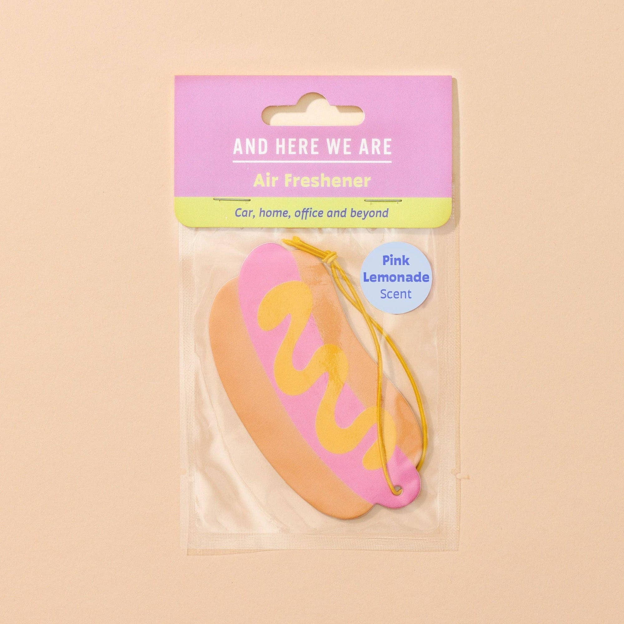 Pink lemonade-scented air freshener with packaging on a beige background