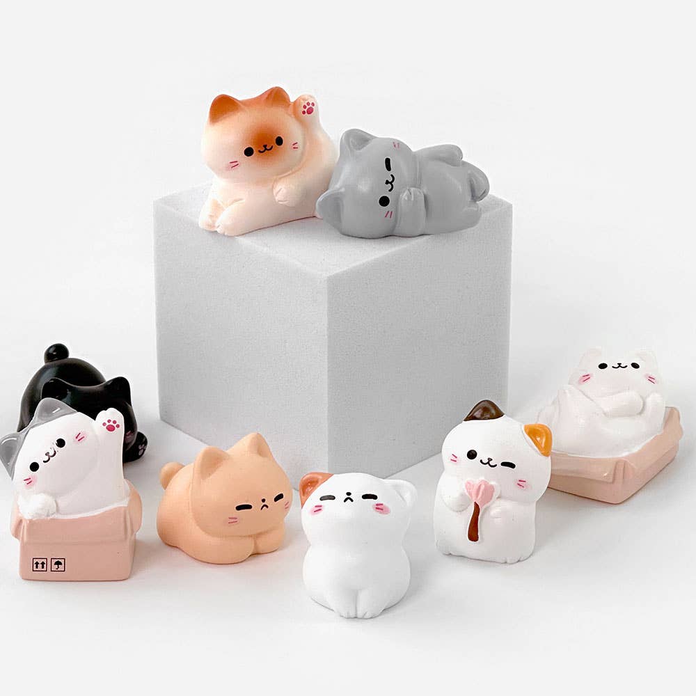 Set of cute cat-shaped figurines on a white background
