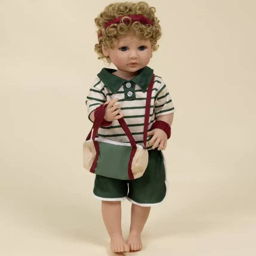 Doll with curly hair wearing a striped shirt and green shorts on a beige background