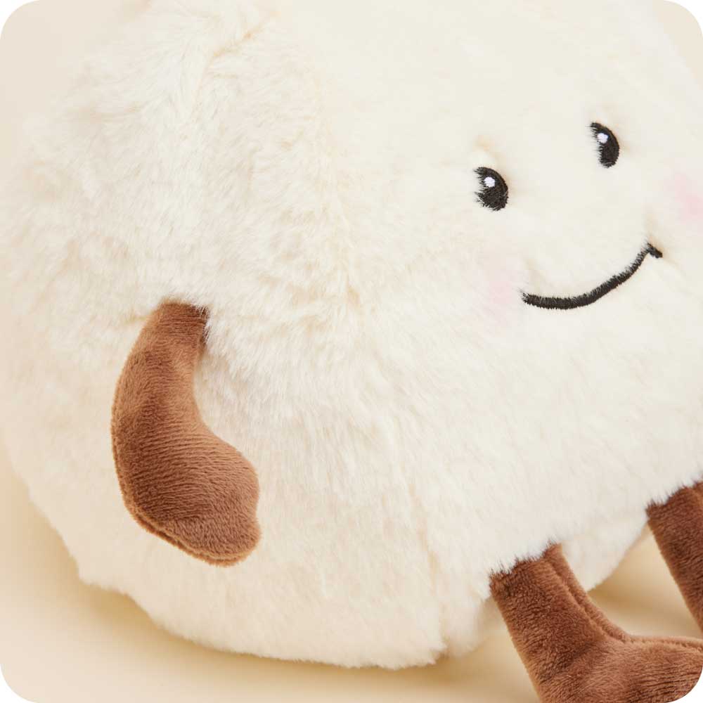 Plush toy dumpling with a smiling face on a beige background