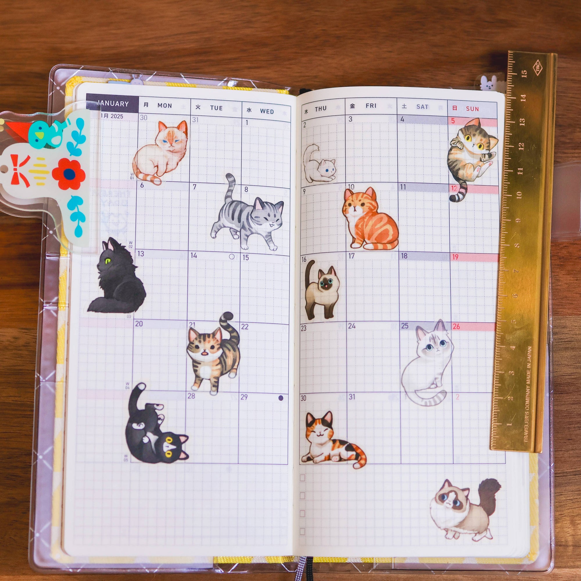 Planner with cat illustrations on a wooden surface