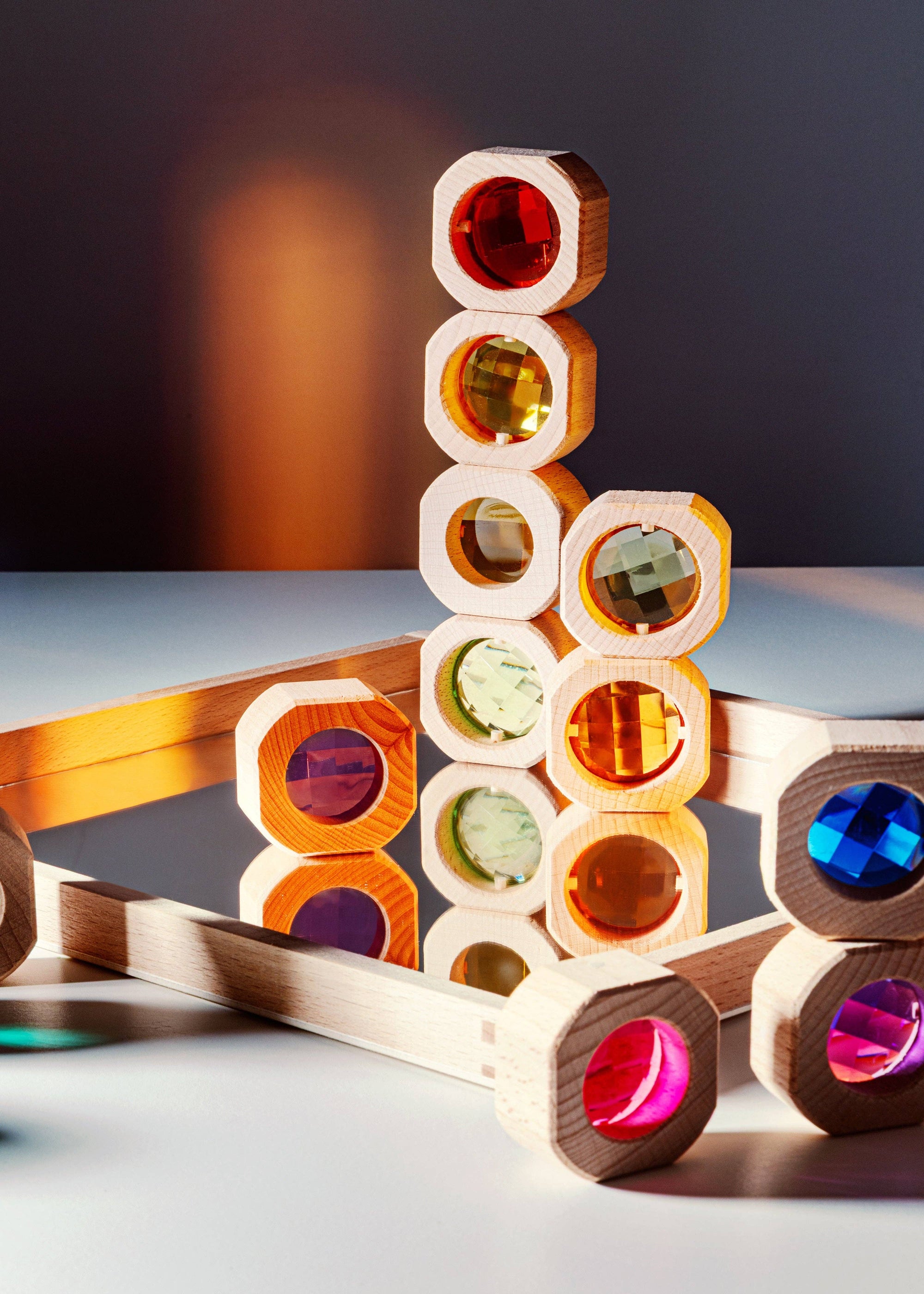 Colorful wooden block tower on a reflective surface with a dark background