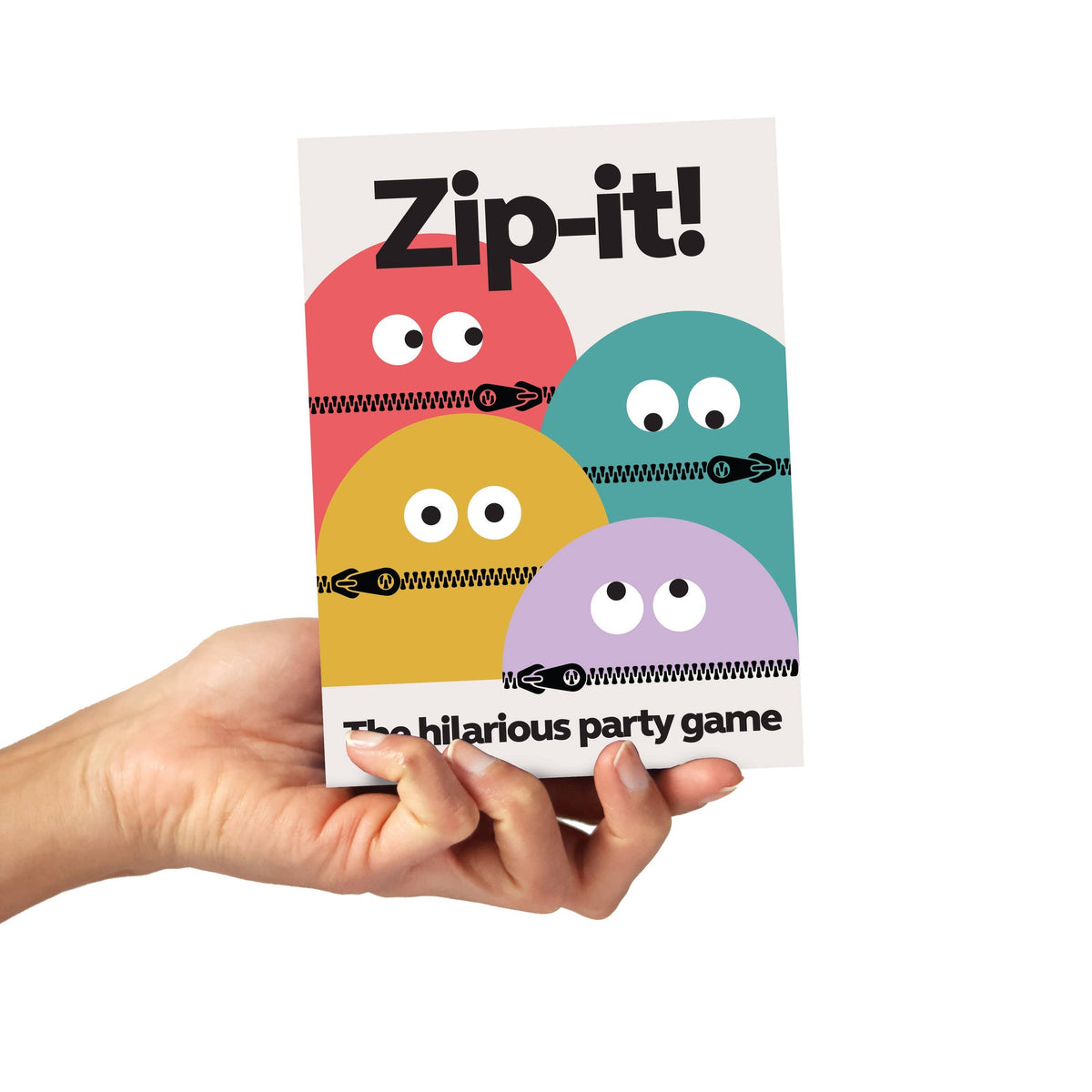 Hand holding a 'Zip-it!' game box with colorful monster faces on a white background