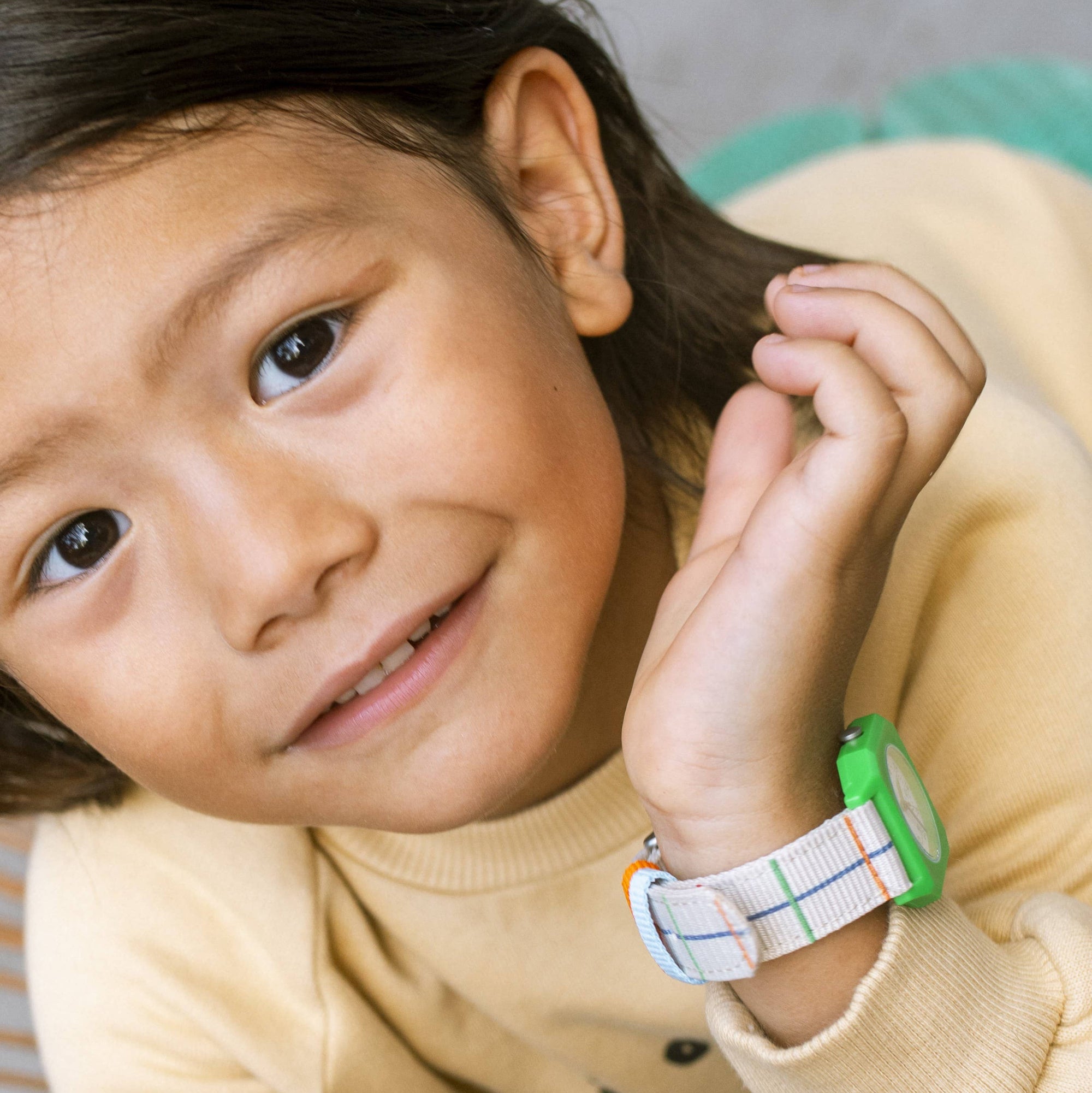Child wearing a colorful watch on a blurred background