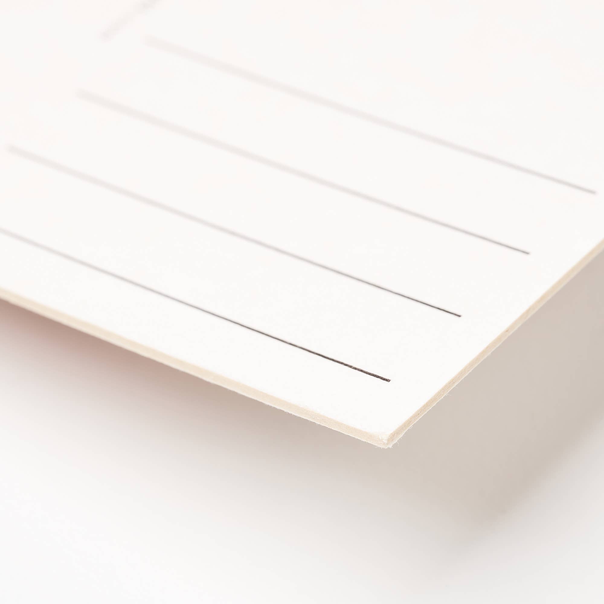 Close-up of a white sheet of paper with ruled lines on a light beige background
