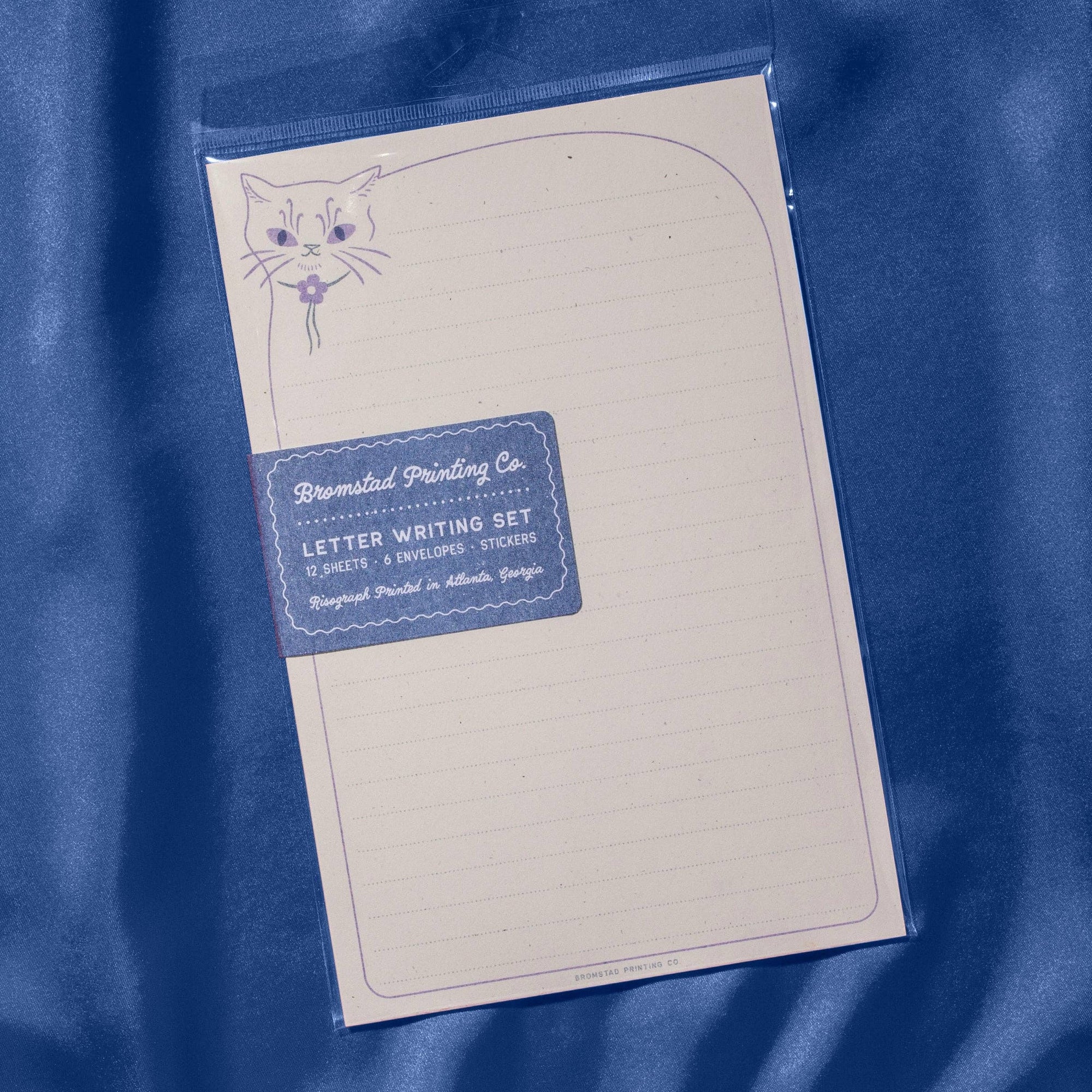 Letter writing set with envelope and stationery on a blue fabric background