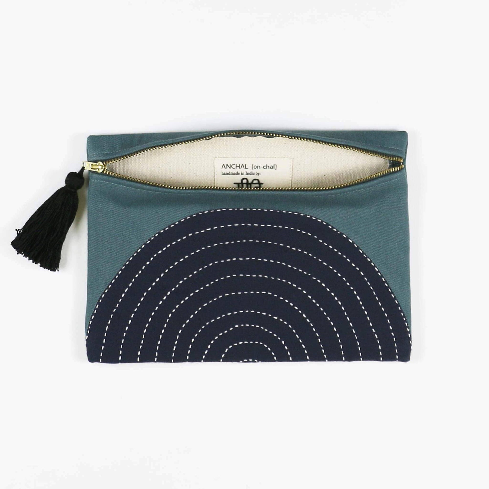Teal pouch with navy circular pattern and tassel on a white background