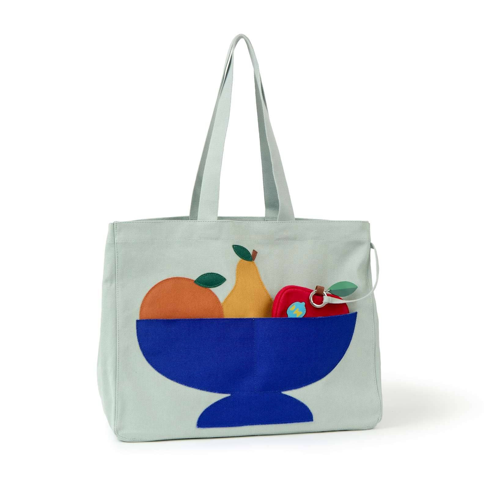 Light blue tote bag with a design of a blue bowl containing fruits on a white background
