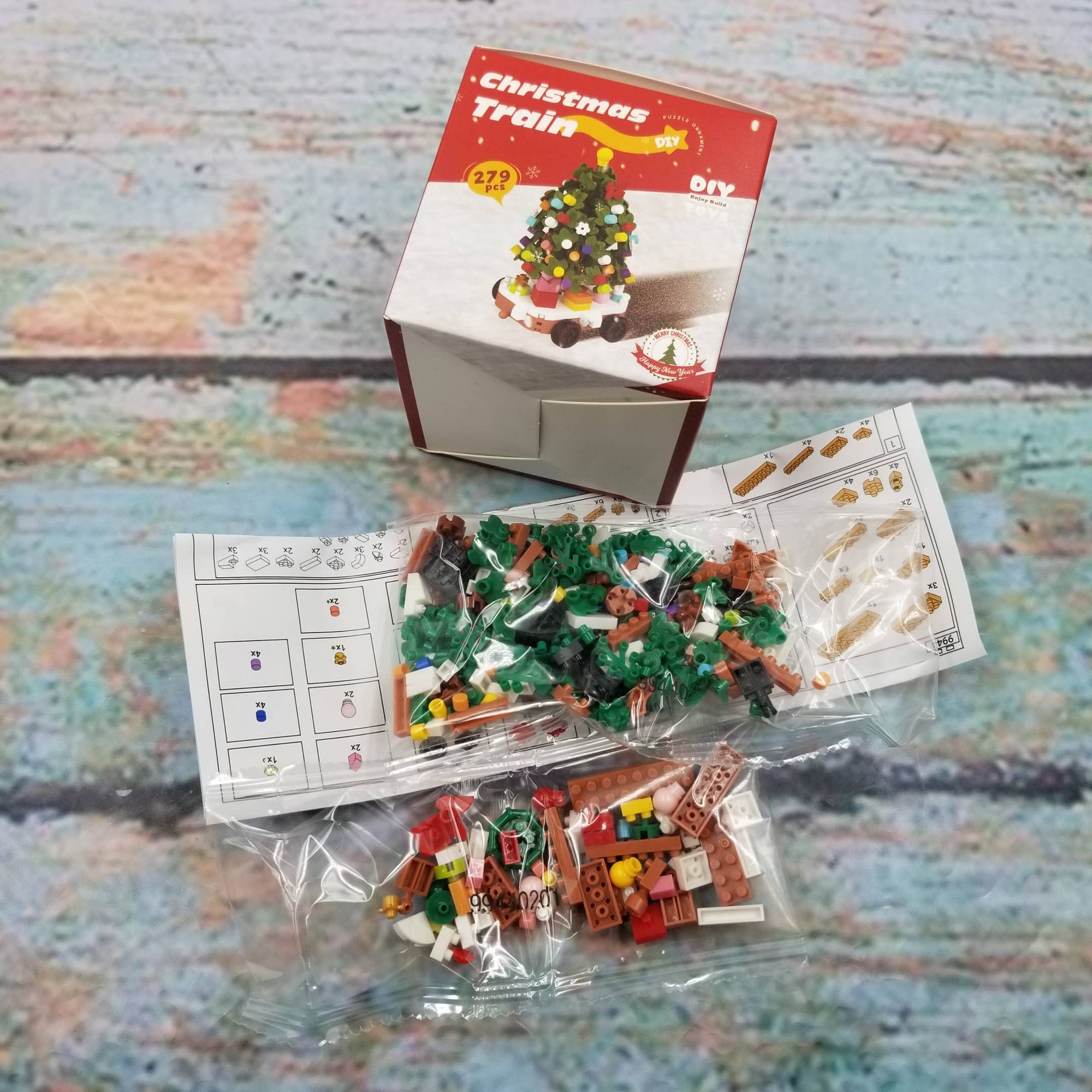 LEGO Christmas train set with packaging and instructions on a textured surface