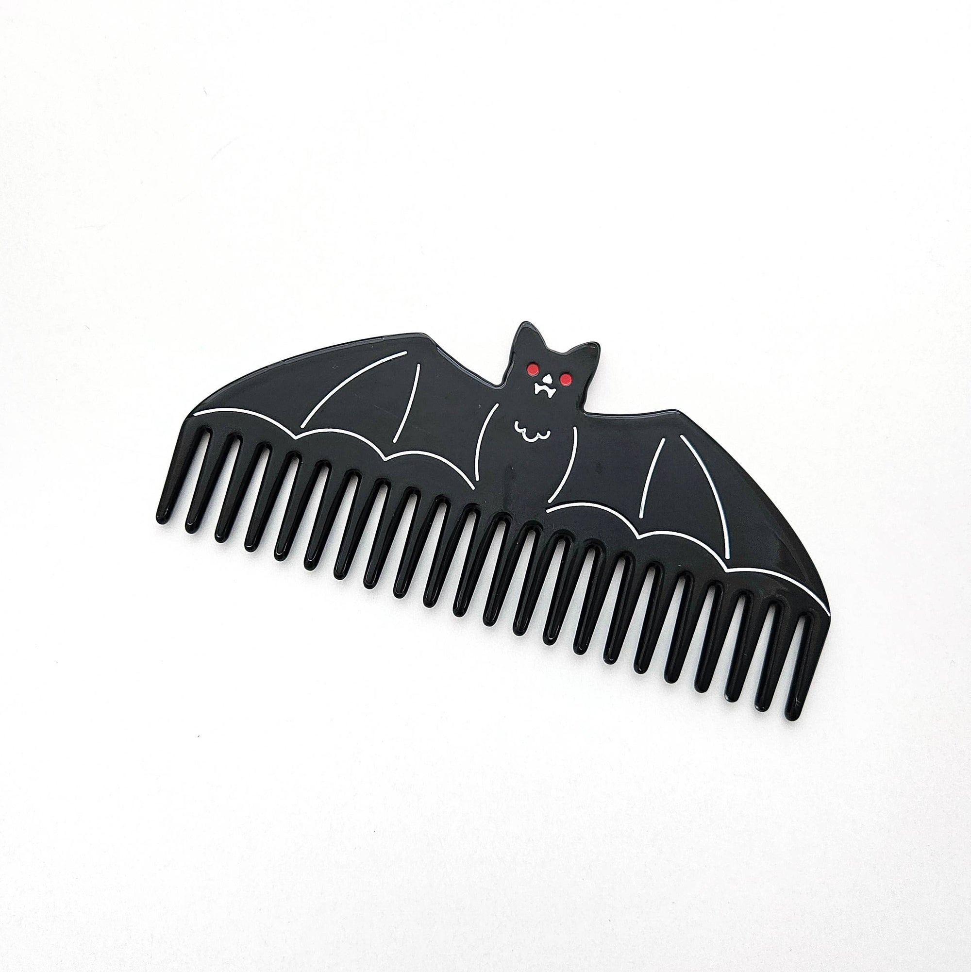Black bat-shaped comb on a white background