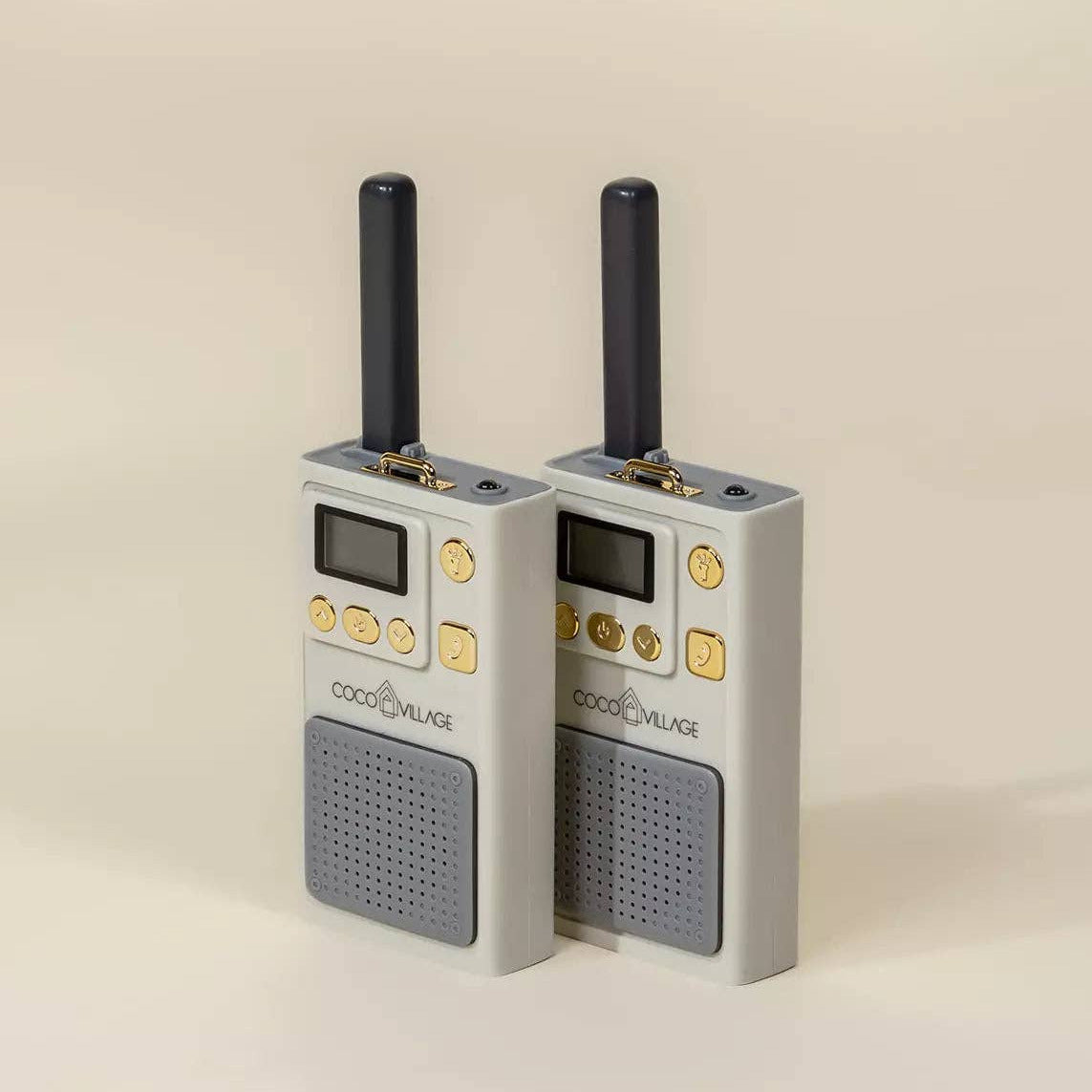 Two gray walkie-talkies with antennas on a beige background