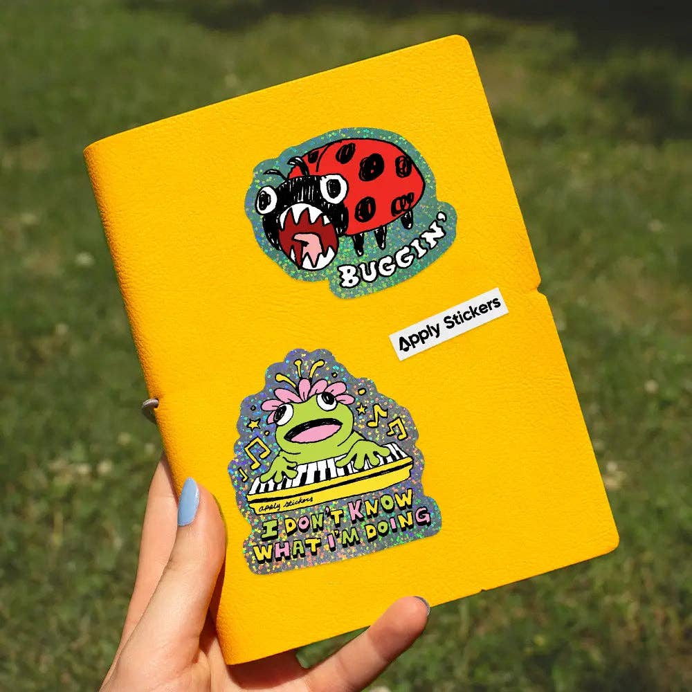 Yellow notebook with stickers on a grassy background