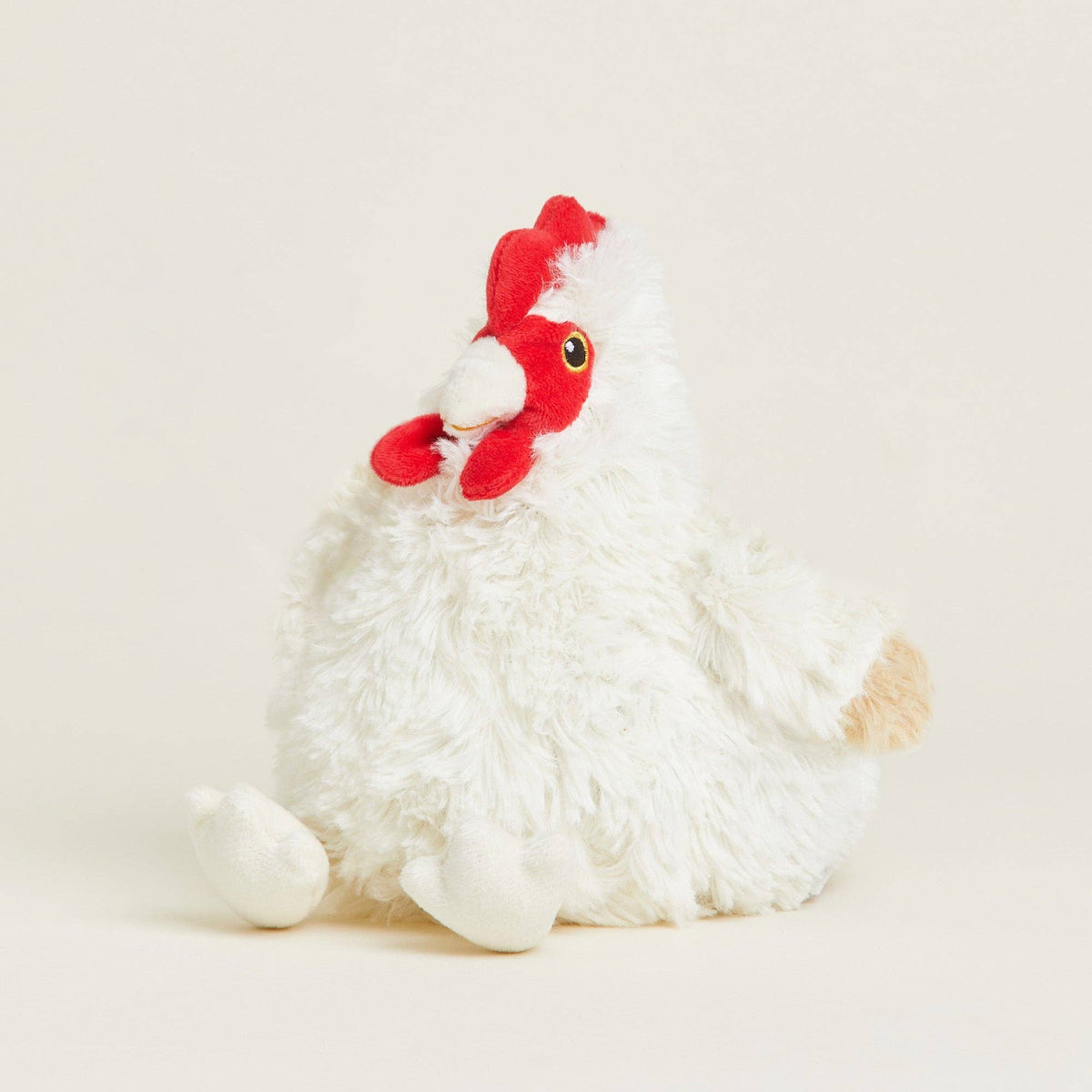 White plush rooster toy with a red comb on a light beige background