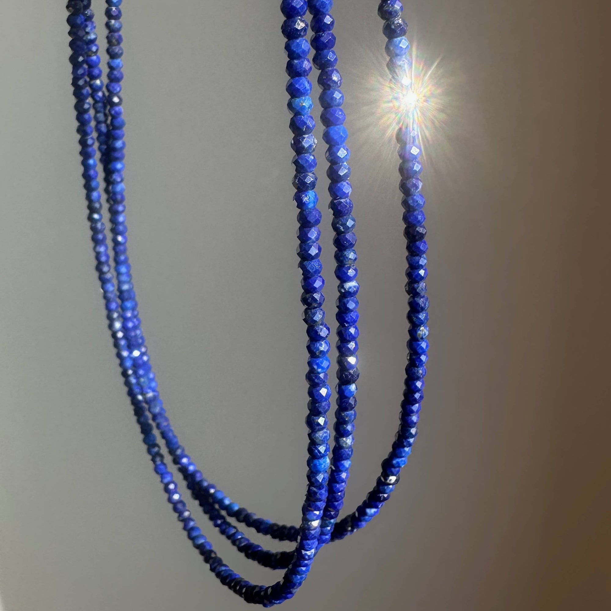 Blue beaded necklace on a plain background