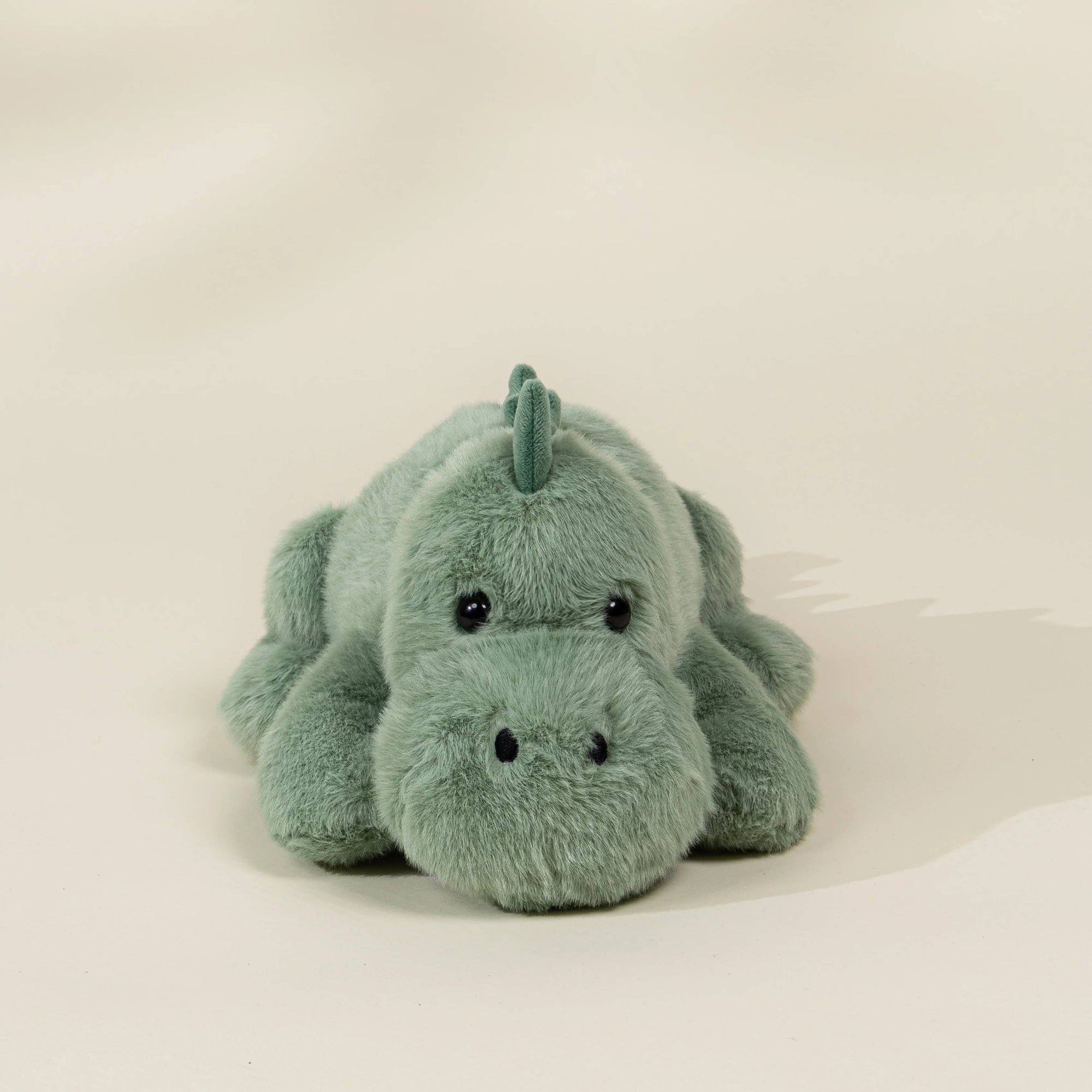 Plush toy dragon on a light beige background