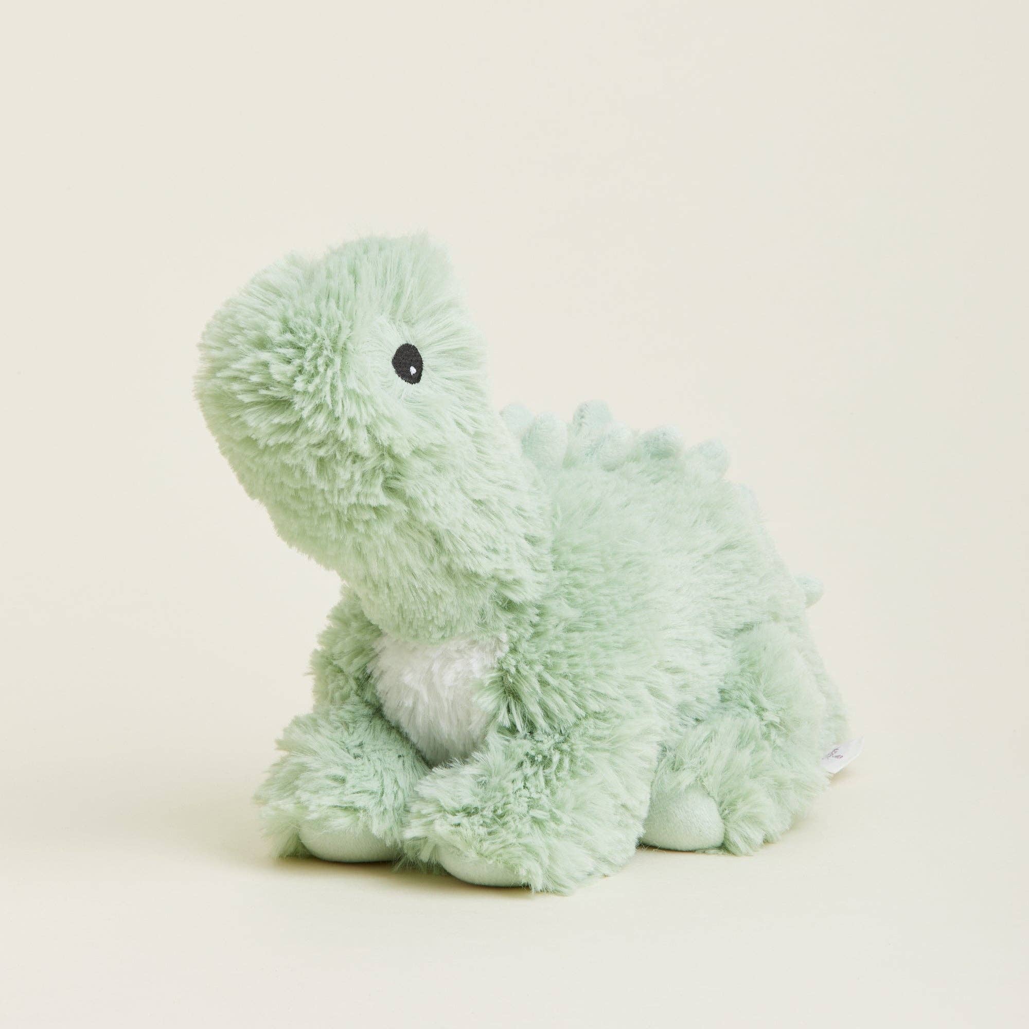 Light green plush toy on a beige background