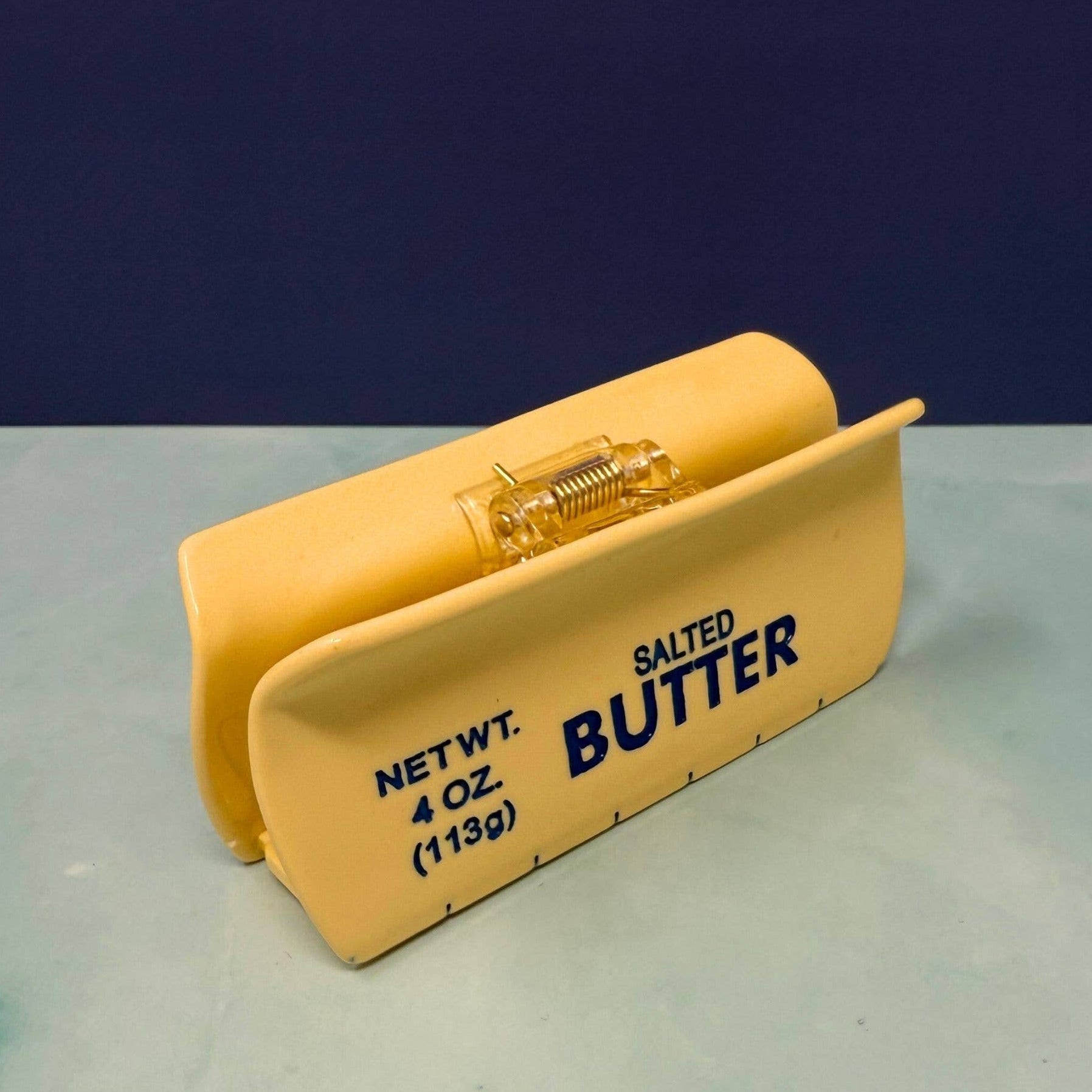 Butter container with 'Salted Butter' text on a gray surface and blue background