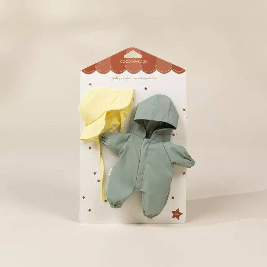 Baby romper and yellow umbrella on a white card with red border against a beige background