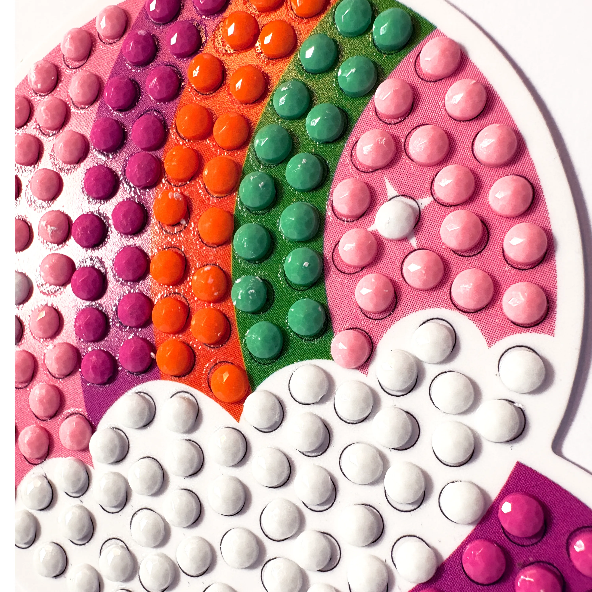 Colorful round stickers arranged in a circular pattern with pink, orange, green, and white colors.